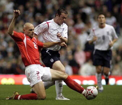 Mariusz Jop (Polen, li.) gegen Wayne Rooney (England) - EDITORIAL USE ONLY. No use with unauthorised audio, video, data, fixture lists, club league logos or live services. Online in-match use limited to 120 images, no video emulation. No use in betting, games or single club league player publications. Fußball Länderspiel Herren Weltmeisterschaftsqualifikation 2005, Qualifikation, Länderspiel, Nationalmannschaft, Nationalteam, Gruppe Manchester Dynamik, Kampf,