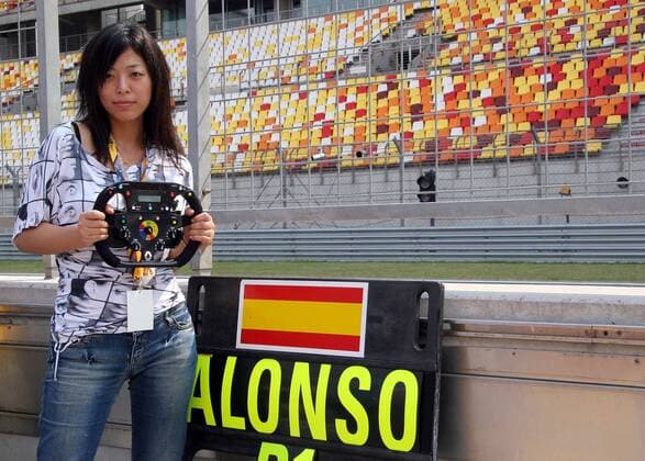 Ein Chinesisches Boxengirl posiert mit einem Renault Lenkrad neben der Anzeigetafel von Fernando Alonso (Spanien Renault) Motorsport Grand Prix Herren Großer Preis von China 2005, Formel 1 Weltmeisterschaft, F1, F, GP, WM Gruppe Shanghai