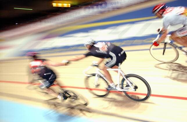 Wechsel zweier Bahnradfahrer - Der Fahrer li. zieht seinen Partner an und verläßt kurze Zeit später die Bahn Radsport Herren 64. Dortmunder 6 Tage Rennen 2005, Sechstagerennen, Sechstage, Sechs, Sixdays, six days, Rad Gruppe Dortmund Dynamik,