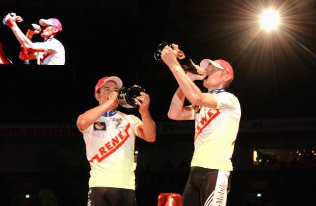 Siegerehrung Dortmunder Sechstagerennen 2005: Erik Zabel (li.) und Rolf Aldag (beide Deutschland) nehmen einen kräftigen Schluck aus der Champagnerflasche Radsport Herren 64. Dortmunder 6 Tage Rennen 2005, Sechstagerennen, Sechstage, Sechs, Sixdays, six days, Rad Gruppe Anzeige, Tafel, Videowand, Sieger, Abbild Dortmund,