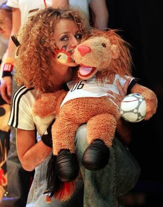 Model küsst Maskottchen Goleo VI. während der Präsentation des neuen Nationaltrikots für die Weltmeisterschaft 2006 Fußball WM Herren Nationalmannschaft 2005, Nationalteam, Nationaltrikot, Vorstellung, Präsentation, Pressetermin Gruppe Sportartikel, küssen, Talisman, Glücksbringer Köln