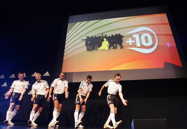 Models präsentieren im Zeichen von +10, der größten globalen Fußballmarketingkampagne von adidas, die neuen Nationaltrikots für die Weltmeisterschaft 2006 Fußball WM Herren Nationalmannschaft 2005, Nationalteam, Nationaltrikot, Vorstellung, Präsentation, Pressetermin Totale Videoleinwand, Kampagne, Werbekampagne, Marketing Köln, zehn, + 10, Kommunikationskampagne, Show,