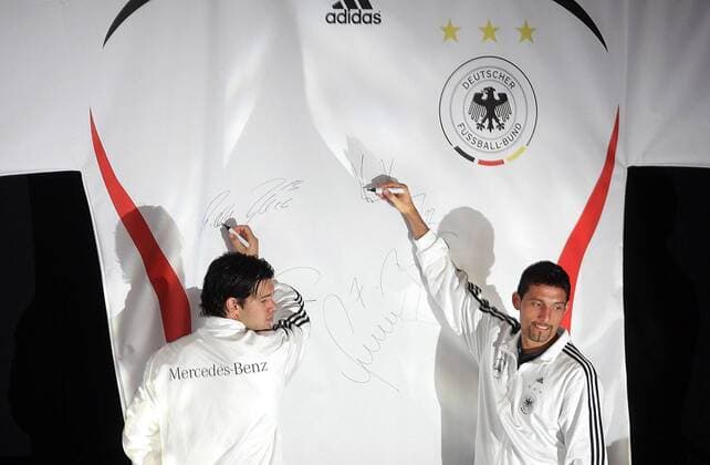 Michael Ballack (li.) und Kevin Kuranyi (beide Deutschland) signieren das neue Nationaltrikot für die Weltmeisterschaft 2006 Fußball WM Herren Nationalmannschaft 2005, Nationalteam, Nationaltrikot, Vorstellung, Präsentation, Pressetermin Gruppe Logo, Emblem, Verbandslogo, Verbandsemblem Köln, übergroß, unterschreiben, Unterschrift