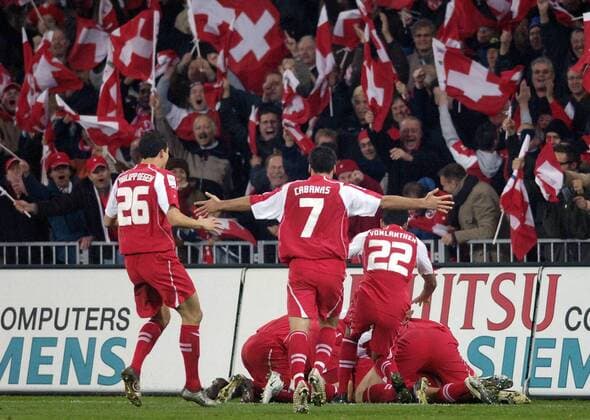 Torjubel Schweiz vor den begeisterten Fans mit Landesfahnen, u.a. v.li.: Philipp Degen, Ricardo Cabanas und Johan Vonlanthen Fußball Länderspiel Herren Weltmeisterschaftsqualifikation 2005, Qualifikation, Länderspiel, Relegation, Playoffs, Playoff Totale Nationalmannschaft, Nationalteam, Nationaltrikot Bern Begeisterung, Freude,