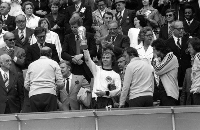 Weltmeister BR Deutschland, v.li.: DFB Präsident Hermann Gösmann, Bundestrainer Helmut Schön, Bundeskanzler Helmut Schmidt, Bernd Hölzenbein mit dem WM Pokal, Horst Dieter Höttges, Bernd Cullmann, Jupp Heynckes, dahinter Pele (Brasilien, 3.R.re.) und ... Fußball WM Herren Weltmeisterschaft 1974, Nationalmannschaft, Nationalteam, Nationaltrikot, Länderspiel, Finale, BRD Totale Ehrentribüne, Tribüne, Tribünen, Politik, Ehefrau München, Zuschauer, Publikum, people, Kanzler Glück, Freude,