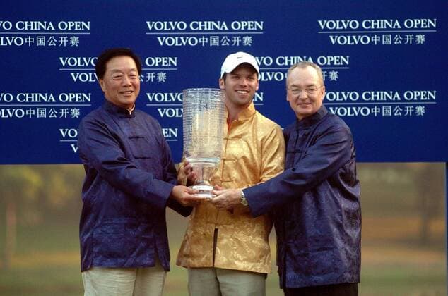 Paul Casey (England, Mitte) ist Sieger der Volvo China Open 2005 - Als Belohnung erhält er einen gläsernen Pokal und ein goldenes Outfit, Mel Pyatt (USA Präsident und Geschäftsführer Volvo Event Management, re.) freut sich mit - Golf Herren Volvo China Open 2005, PGA European Tour, Golfen, Asian, Schrift, typical, typisch, landestypisch Gruppe IMCp05539702 asiatisches Gewand Shenzhen Golf Club Asien Freude,
