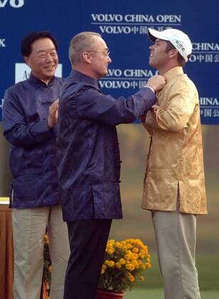 Paul Casey (England, re.) ist Sieger der Volvo China Open 2005 - Als Belohnung erhält er von Ex Golfprofi Mel Pyatt (USA Präsident und Geschäftsführer Volvo Event Management) ein goldenes Outfit -  Golf Herren Volvo China Open 2005, PGA European Tour, Golfen, Asian, typical, typisch, landestypisch Gruppe IMCp05539705 asiatisches Gewand Shenzhen Golf Club Asien