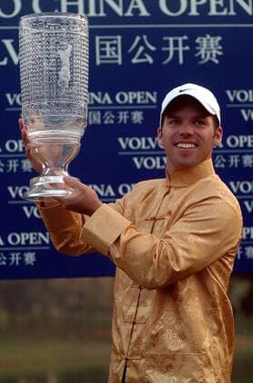 Paul Casey (England) ist Sieger der Volvo China Open 2005 - In traditionell chinesischem Goldoutfit präsentiert er den gläsernen Pokal -  Golf Herren Volvo China Open 2005, PGA European Tour, Golfen, Asian, typical, typisch, landestypisch Einzelbild IMCp05539712 asiatisches Gewand Shenzhen Golf Club Asien Freude,