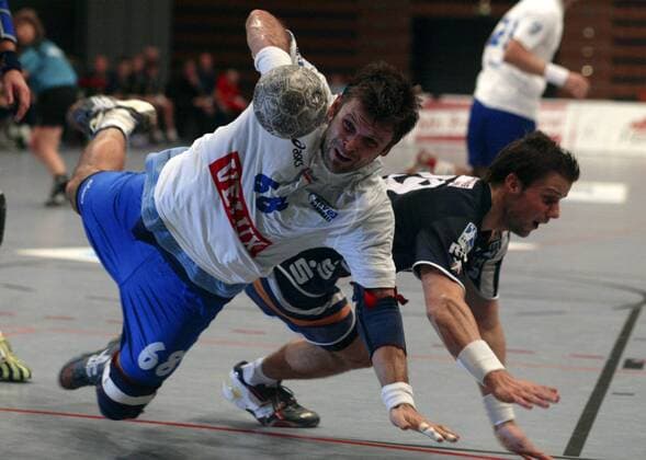 Andreas Rastner (Hamburg, li.) kommt gegen Frank Schumann (Nordhorn) zu Fall Handball 1. BL Herren DHB Pokal 2005 2006, HSV Hamburg - HSG Nordhorn 32:31 Gruppe Pokalspiel Hamburg Dynamik, Kampf,