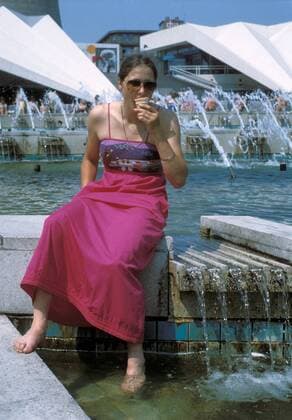 Karin Enke (DDR SC Einheit Dresden) kühlt sich bei sommerlichen Temperaturen ab, ein Eis im Mund und die Füße im Wasser des Springbrunnens am Berliner Alexanderplatz Eisschnellauf Damen Eisschnellaufen 1982, Eisschnelllauf, Eisschnelllaufen, Vdia Einzelbild Berlin