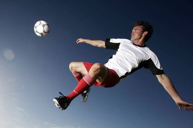 Fußballspieler mit einem akrobatischen Seitfallzieher - MODEL RELEASED Fußball Herren Freizeitfußball 2005, Symbol, Feature, Aufmacher, Freizeitsport, Freizeitsportler, Fußballspieler Einzelbild akrobatische Dynamik,