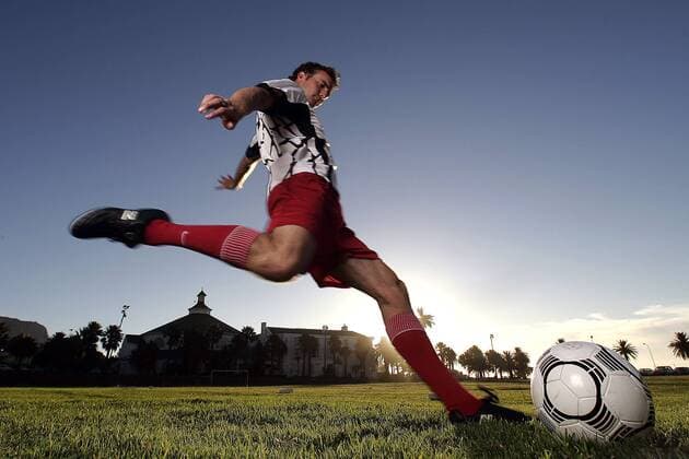 Fußballspieler beim Torschuß unter blauem Himmel - MODEL RELEASED Fußball Herren Freizeitfußball 2005, Symbol, Feature, Aufmacher, Freizeitsport, Freizeitsportler, Fußballspieler Einzelbild Dynamik,
