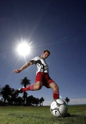 Fußballspieler beim Torschuß unter Sonnenschein - MODEL RELEASED Fußball Herren Freizeitfußball 2005, Symbol, Feature, Aufmacher, Freizeitsport, Freizeitsportler, Wirtschaft Einzelbild Nike, Ausrüstung, Equipment Licht, Sonne, Sportgerät, Spielgerät, Schuss Dynamik,