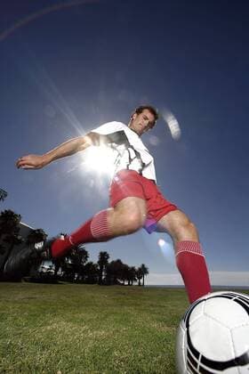 Fußballspieler beim Torschuß unter Sonnenschein - MODEL RELEASED Fußball Herren Freizeitfußball 2005, Symbol, Feature, Aufmacher, Freizeitsport, Freizeitsportler Einzelbild Dynamik,