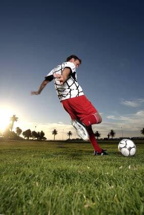 Fußballspieler beim Torschuß vor tiefstehender Sonne - MODEL RELEASED Fußball Herren Freizeitfußball 2005, Symbol, Feature, Aufmacher, Freizeitsport, Freizeitsportler Einzelbild hinten, Rücken, Rückansicht Dynamik,
