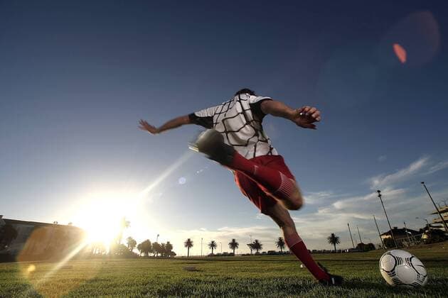 Fußballspieler beim Torschuß vor tiefstehender Sonne - MODEL RELEASED Fußball Herren Freizeitfußball 2005, Symbol, Feature, Aufmacher, Freizeitsport, Freizeitsportler Einzelbild hinten, Rücken, Rückansicht Dynamik,