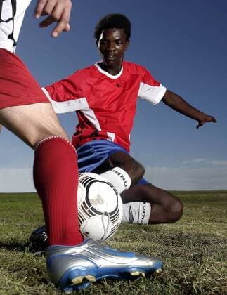Fußballspieler grätscht in einem Zweikampf - MODEL RELEASED Fußball Herren Freizeitfußball 2005, Symbol, Feature, Aufmacher, Freizeitsport, Freizeitsportler Gruppe Sportgerät, Spielgerät, Ausrüstung, Equipment Froschperspektive, unten, Zweikampf, Duell