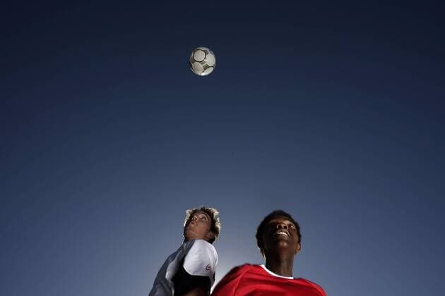 Fußballspieler fixieren den Ball in der Luft - MODEL RELEASED Fußball Herren Freizeitfußball 2005, Symbol, Feature, Aufmacher, Freizeitsport, Freizeitsportler Gruppe Duell, Luftkampf, Luftduell, Froschperspektive, unten, Zweikampf, Duell Höhe,