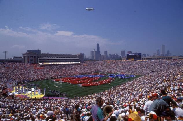 Eröffnungsveranstaltung der WM 1994 - ein buntes Spektakel wird auf dem Spielfeld vorgeführt, im Hintergrund am Horizont die Skyline von Downtown Chicago Fußball WM Herren Weltmeisterschaft 1994, Eröffnungszeremonie, Zeremonie, Eröffnung, Veranstaltung, Show, Showprogramm Totale Soldier Field Stadium, Stadion Chicago, Eröffnungsfeier, feiern, Feier