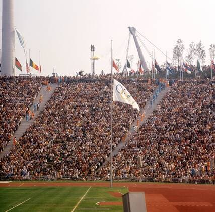 Die olympische Fahne im voll besetzten Olympiastadion hängt während der Trauerfeier für die Opfer der Geiselnahme auf Halbmast Leichtathletik OS Sommer Herren Olympische Spiele 1972, Sommerspiele, Attentat, Attentate, Olympiaattentat, Tragödie, Mfdia Totale München