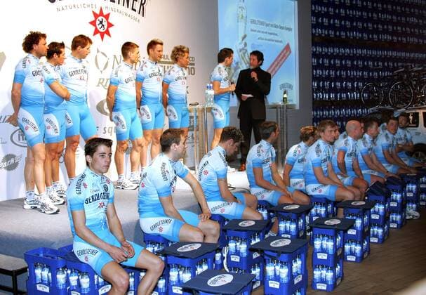 Das Team Gerolsteiner stellt sich vor, Wasserkisten des Getränkeherstellers dienen den Sportlern als Sitzgelegenheit Radsport Herren Straßenradsport 2006, Straße, Rad, Präsentation, Pressetermin, Vorstellung Totale Gerolstein