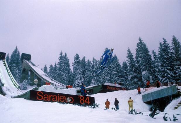 Sarajevo 84 - Markku Pusenius (Finnland) springt von der Normalschanze, daneben die Großschanze Skispringen OS Winter Herren Olympische Spiele 1984, Winterspiele, Ski Nordisch, Skisport, Vdia Totale Igman Malo Polje Sarajevo, Skisprunganlage
