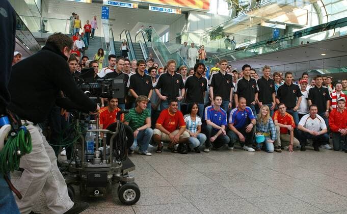 Das Nationalteam aus Deutschland zwischen etlichen Statisten während der Dreharbeiten zum T Com Werbespot, v. li.: Fabian Ernst, Sebastian Deisler, Torwart Oliver Kahn, Patrick Owomoyela, Per Mertesacker, Michael Ballack, Marcell Jansen... Fußball Herren Nationalmannschaft 2006, Nationalteam, Shooting, Fotoshooting, Fototermin, Werbepartner Totale Kameramann, filmen, Aufnahme, Filmaufnahme, Halle, Düsseldorf, Messehalle