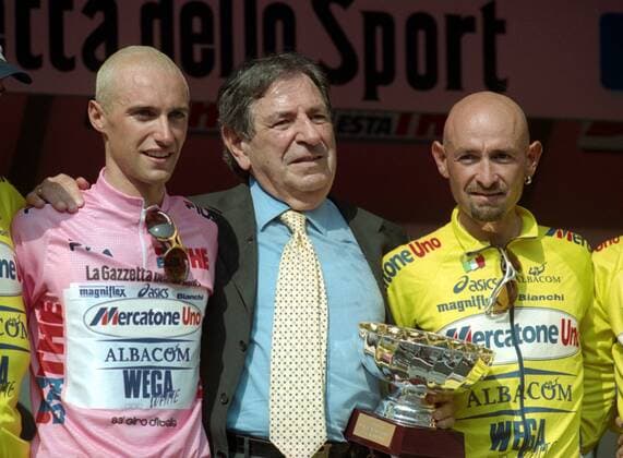 Gesamtsieger Stefano Garzelli (li.) und sein Teamkollege Marco Pantani (re., beide Italien Mercatone Uno) mit einem Offiziellen sowie einem Pokal während der Siegerehrung -  Radsport Herren Giro d Italia 2000, dItalia, Straßenradsport, Straße, Rad, Vneg Gruppe 21. Etappe: Turin - Mailand Freude,