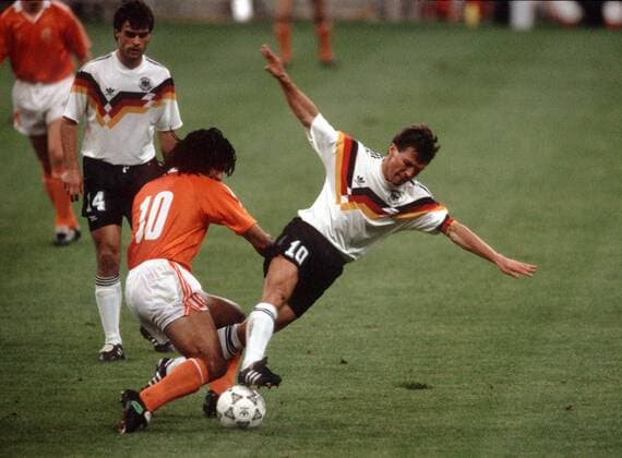 Lothar Matthäus (BR Deutschland, re.) wird von Ruud Gullit (Niederlande, 2.v.li.) zu fall gebracht, Thomas Berthold (BR Deutschland) schaut zu Fußball WM Herren Weltmeisterschaft 1990, Nationalmannschaft, Nationalteam, Nationaltrikot, Länderspiel, Achtelfinale Gruppe Mailand Dynamik, Kampf,