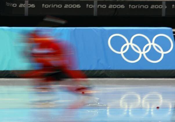 Eine Eisschnellläuferin fährt während der Sprintstrecke an den olympischen Ringen vorbei Eisschnellauf OS Winter Damen Olympische Spiele 2006, Winterspiele, 500m, 500 m, Meter, Sprint Einzelbild Turin Dynamik,