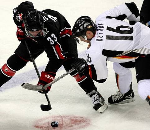 Kris Draper (Kanada, li.) gegen Stefan Ustorf (Deutschland) - Bully Eishockey OS Winter Herren Olympische Spiele Turin 2006, Winterspiele, Nationalmannschaft, Nationalteam, Nationaltrikot Gruppe Turin Dynamik,