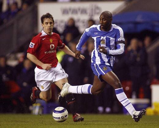Jason Roberts (Wigan, re.) verfolgt von Gary Neville (Manchester United) - EDITORIAL USE ONLY. No use with unauthorised audio, video, data, fixture lists, club league logos or live services. Online in-match use limited to 120 images, no video emulation. No use in betting, games or single club league player publications. Fußball Herren English Premier League 2005 2006, 1. Englische Liga, Wigan Athletic - Manchester United 1:2, ManU Gruppe Wigan Dynamik,