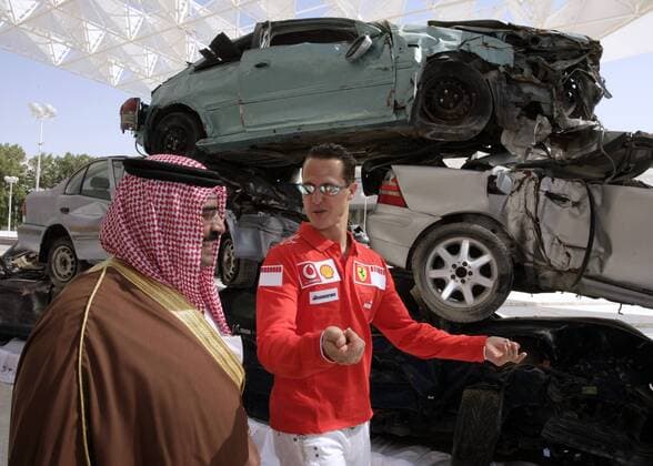 Michael Schumacher (Deutschland Ferrari, re.) im Gespräch mit einem Scheich neben gestapelten Autowracks Motorsport Grand Prix Herren Großer Preis von Bahrain 2006, Formel 1 Weltmeisterschaft, F1, F, GP, WM, Gruppe Sakhir Manama