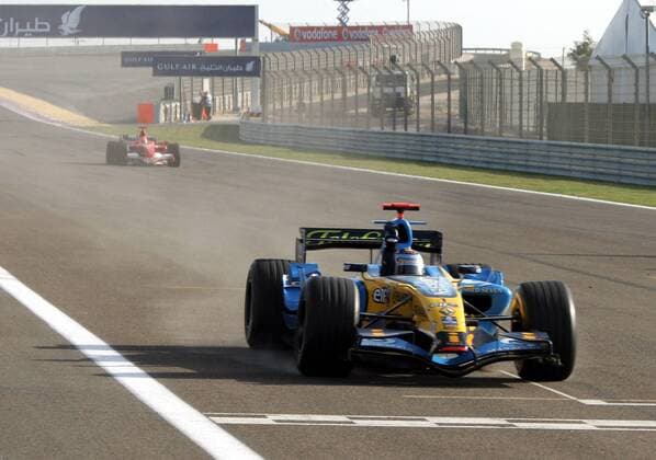 Sieger Fernando Alonso (Spanien Renault) jubelt bei der Zieldurchfahrt im Cockpit seines Boliden, im Hintergrund der Zweitplatzierte Michael Schumacher (Deutschland Ferrari) Motorsport Grand Prix Herren Großer Preis von Bahrain 2006, Formel 1 Weltmeisterschaft, F1, F, GP, WM Totale Bahrain International Circuit Manama, Sakhir Freude,