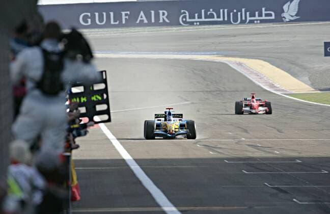 Sieger Fernando Alonso (Spanien Renault) jubelt bei der Zieldurchfahrt im Cockpit seines Boliden, im Hintergrund der Zweitplazierte Michael Schumacher (Deutschland Ferrari) Motorsport WM Herren Großer Preis von Bahrain 2006, Formel 1 Weltmeisterschaft, F1, F, GP, WM Totale Manama, Sakhir Freude,
