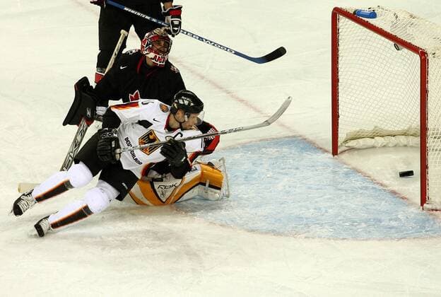 Stefan Ustorf (Deutschland, re.) trifft gegen Goalie Roberto Luongo (Kanada) Eishockey OS Winter Herren Olympische Spiele 2006, Winterspiele, Nationalteam, Nationalmannschaft, Nationaltrikot, Länderspiel Gruppe Turin Dynamik,