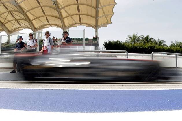 Kimi Räikkönen (Finnland McLaren Mercedes) rast in seinem Boliden an Technikern verschiedener Teams auf der Tribüne vorbei Motorsport Grand Prix Herren Großer Preis von Malaysia 2006, Formel 1 Weltmeisterschaft, F1, F, GP, WM, Vdig Totale Sepang Kuala Lumpur Dynamik,