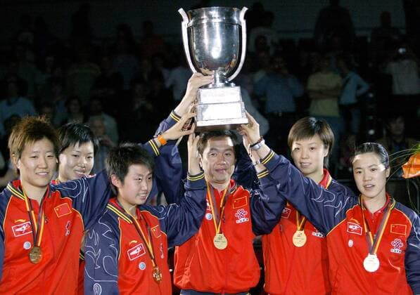 Mannschaftsweltmeisterinnen aus China während der Siegerehrung - v.li.: Guo Yan, Li Xiaoxia, Guo Yue, Nationaltrainer Shi Zhihao mit der Trophäe, Zhang Yining und Wang Nan Tischtennis WM Damen Mannschaftsweltmeisterschaft 2006, Mannschaftsweltmeisterschaften, Mannschafts, Team, Finale Gruppe Podium, Podest, Pokal, Trophäe, Bremen lächeln Freude,