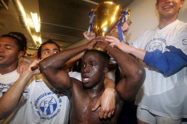 Alhassane Keita (FC Zürich, Mitte) jubelt mit dem Schweizer Meisterpokal und seinen Mannschaftskameraden in der Kabine -  Fußball Herren Super League 2005 2006, Nationalliga A, NLA, 1. Schweizer Liga, Meistershirt, Umkleide Gruppe Basel Begeisterung, Freude,