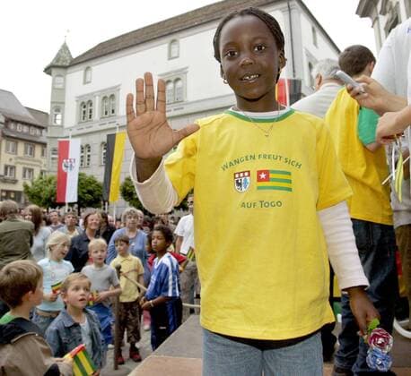 Willkommensparty für die Nationalmannschaft aus Togo in Wangen i.A. - Die kleine Jasmin begrüßt das togolesische Nationalteam bei der Ankunft mit einem T Shirt - Wangen freut sich auf Togo Fußball WM Herren Vorschau Weltmeisterschaft 2006, Nationalmannschaft, Nationalteam, Empfang, Party, Vdig Einzelbild Wangen i. A. Freude,