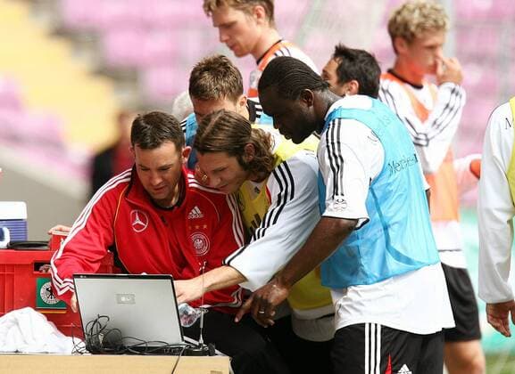 Trainingsberater Craig Friedman (USA Athlete Performance, li.) zeigt Torsten Frings (Mitte) und Gerald Asamoah (beide Deutschland) die Leistungsergebnisse auf seinem Laptop Fußball WM Herren Nationalmannschaft 2006, Vorbereitung, Training Gruppe Genf, Analyse, Trainingsanalyse, Computeranalayse