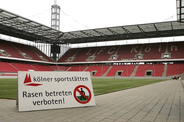 Nur noch der Vereinsname des 1. FC Köln ist im leeren Rhein Energie Stadion auf der Tribüne zu sehen - das FIFA Werbeverbot wurde perfekt umgesetzt und der WM Rasen schon sauber verlegt, deshalb das Schild der Kölner Sportstätten: Rasen betreten verboten Fußball Herren Vorschau Weltmeisterschaft 2006, Vorbereitung, Platzpflege, Rasenpflege, Verbot, Vdig Totale RheinEnergie Stadion, Energy, RheinEnergy Köln, vorbereiten, Rasenverlegung, Verlegung