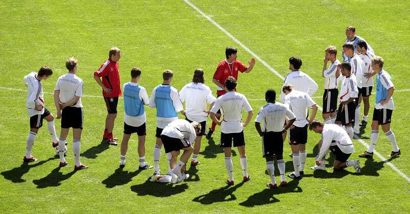 Bundestrainer Jürgen Klinsmann (li.) und die Spieler der Deutschen Nationalmannschaft lauschen der Ansprache von Co Trainer Joachim Löw (beide Deutschland) Fußball WM Herren Nationalmannschaft 2006, Nationalteam, Training, Trainingslager, Vorbereitung Totale Genf