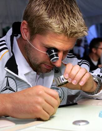 Thomas Hitzlsperger (Deutschland) nimmt eine Uhr, die er vorher selbst auseinader- und wieder zusammengebaut hat genauer unter die Lupe - mit dieser Übung soll das Selbstvertrauen der Nationalspieler gestärkt werden Fußball WM Herren Nationalmannschaft 2006, Nationalteam, Trainingslager, Sponsorentermin, Ausflug Porträt Genf