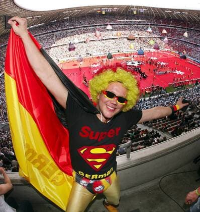 Der deutsche Superman hat sichtlich Spaß an der Eröffnungsfeier der WM 2006 im Münchner WM Stadion -  Fußball WM Herren WM 2006, Eröffnungsfeier, Eröffnung, Zeremonie, Feier, Landesfarben, Nationalfarben Einzelbild World Cup Stadium SuperGerman, Super German München, Verkleidung, verkleidet, Logo, Emblem Freude,