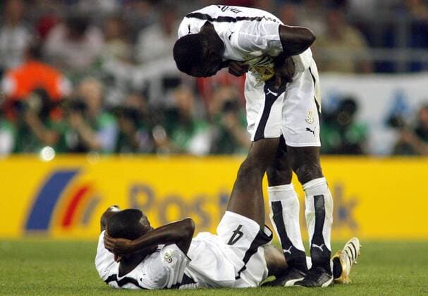 Samuel Osei Kuffour (li.) hat einen Wadenkrampf, John Mensah (beide Ghana) kümmert sich um ihn Fußball WM Herren WM 2006, Länderspiel, Nationalteam, Gruppe E, Ghana, Vdig Gruppe Nationaltrikot Hannover Fußball WM Herren WM 2006, Länderspiel, Nationalteam, Gruppe E, Ghana, Vdig Gruppe Nationaltrikot Hannover