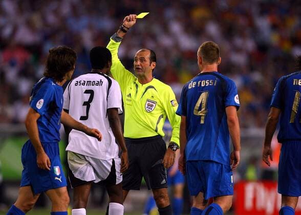 FIFA Schiedsrichter Carlos Simon (Brasilien) zeigt Gyan Asamoah (Ghana, 2.v.li.) die gelbe Karte beobachtet von Andrea Pirlo (li.) und Daniele de Rossi (beide Italien) Fußball WM Herren WM 2006, Länderspiel, Nationalteam, Gruppe E, Nationaltrikot, Italien - Ghana 2:0 Gruppe Hannover Fußball WM Herren WM 2006, Länderspiel, Nationalteam, Gruppe E, Nationaltrikot, Italien - Ghana 2:0 Gruppe Hannover