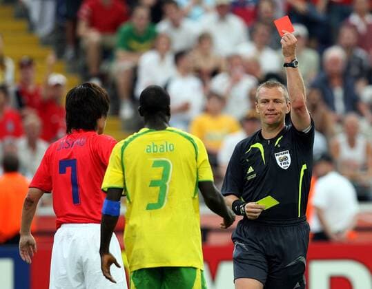 FIFA Schiedsrichter Graham Poll (England) zeigt Jean-Paul Abalo (Togo, Mitte) Gelb Rot, daneben Park Ji Sung (Südkorea) -  Fußball WM Herren WM 2006, Länderspiel, Nationalteam, Nationaltrikot, Gruppe G, Südkorea - Togo 2:1 Korea Gruppe Frankfurt M. Fußball WM Herren WM 2006, Länderspiel, Nationalteam, Nationaltrikot, Gruppe G, Südkorea - Togo 2:1 Korea Gruppe Frankfurt M.