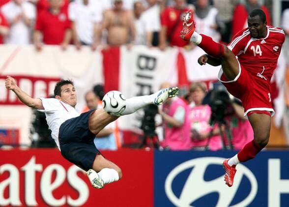 Frank Lampard (England, li.) gegen Stern John (Trinidad und Tobago) - Everybody is Kung Fu Fighting... -  Fußball WM Herren WM 2006, Länderspiel, Nationalteam, Gruppe B, Nationaltrikot, England - Trinidad und Tobago Gruppe Nürnberg Dynamik, Höhe, Fußball WM Herren WM 2006, Länderspiel, Nationalteam, Gruppe B, Nationaltrikot, England - Trinidad und Tobago Gruppe Nürnberg Dynamik, Höhe,