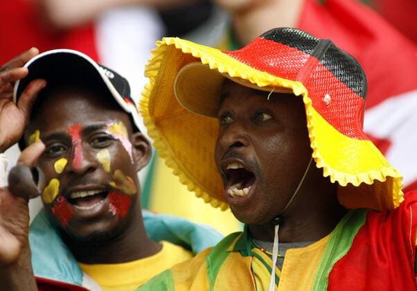Togolesischer Fan mit deutschem Fanhut feuert sein Team lautstark an Fußball WM Herren WM 2006, Länderspiel, Nationalteam, Gruppe G, Togo, Vdig Gruppe Dortmund Fußball WM Herren WM 2006, Länderspiel, Nationalteam, Gruppe G, Togo, Vdig Gruppe Dortmund